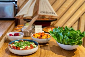 salatki sniadaniowe pomidor ogorek feta przy modelu zaglowki bufet restauracja dwa jeziora kal wegorzewo mazury