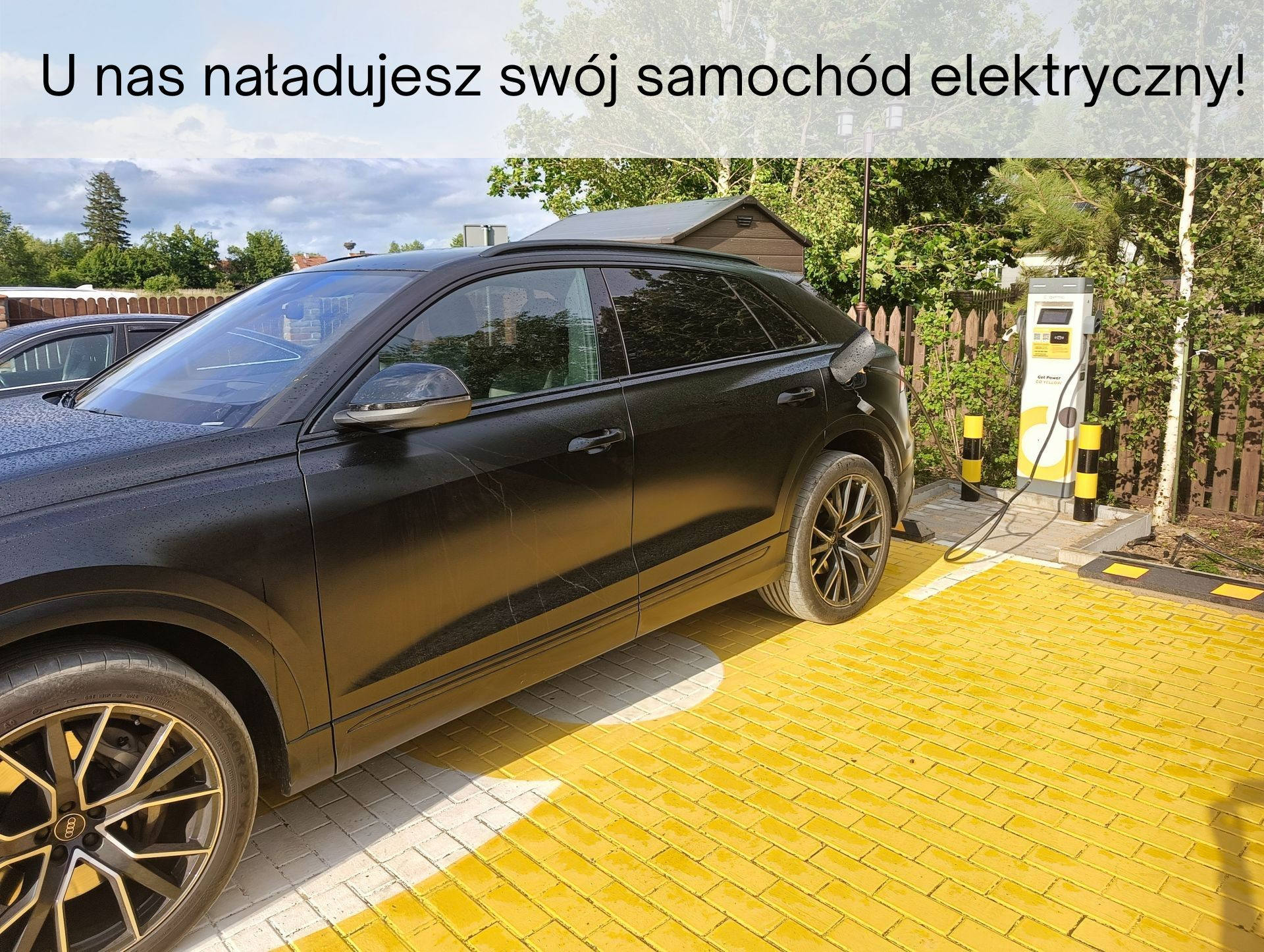 Samochód elektryczny przy ładowarce EV obok Qchni Dwa Jeziora